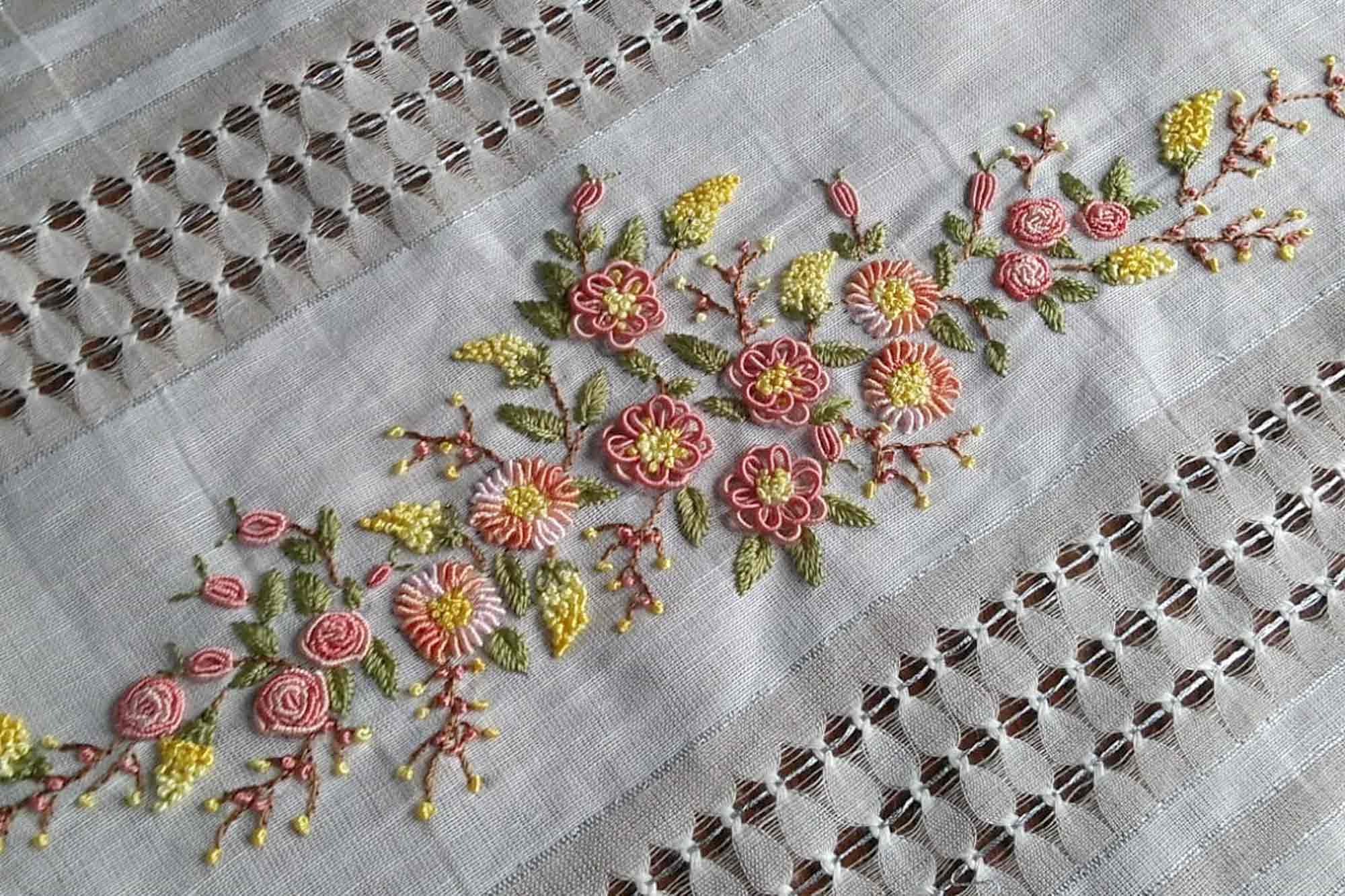 Ajur şeritli beyaz keten üzerine pembe ve sarı çiçek bordürü işlenmiş masa örtüsü
